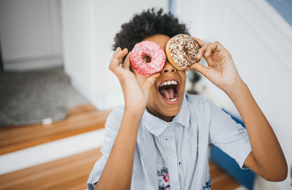 Child in the kitchen eating donuts