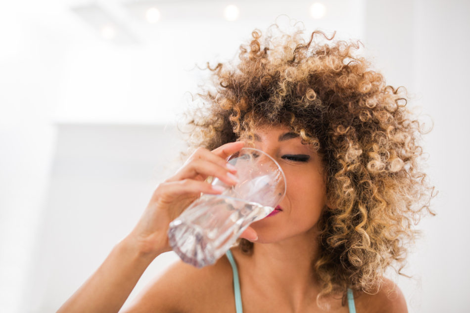 Young woman drinking a glass of water