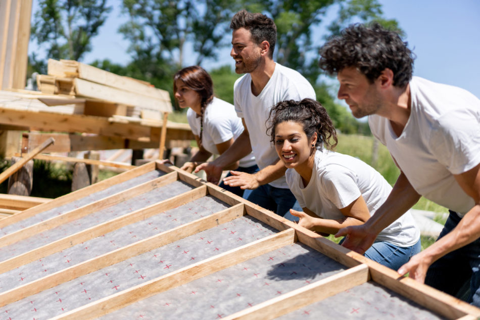 volunteers working hard at a charity construction project - Charity and relief concepts