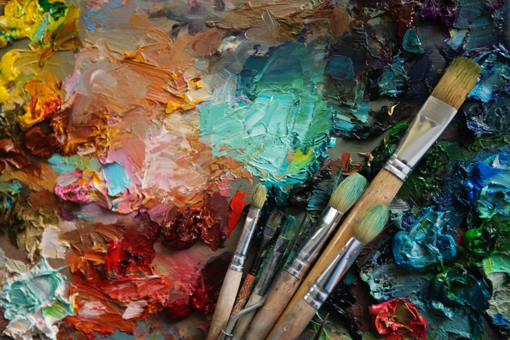 art brushes and oil paints on wooden palette.