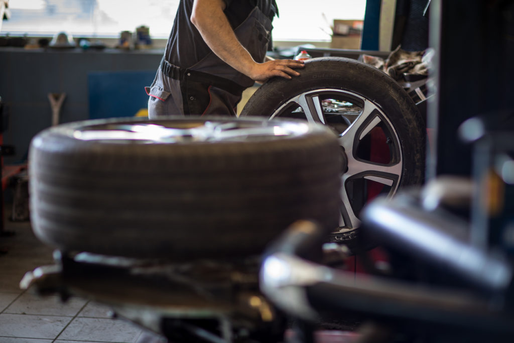 Tire service at auto workshop by mechanic.