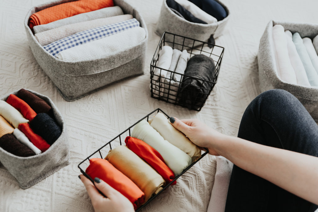 Folding clothes and organizing stuff in boxes and baskets.